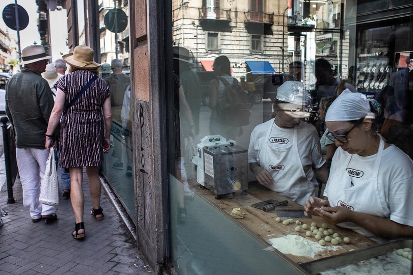 Workers make fresh pasta in a display window at the Ipastari restaurant in Palermo, Sicily, Italy.