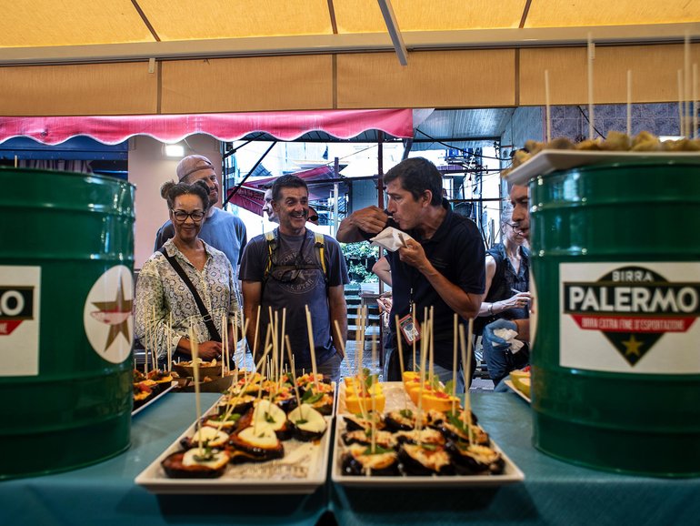 A tour group tries Sicilian foods in Palermo’s Mercato del Capo in Italy.