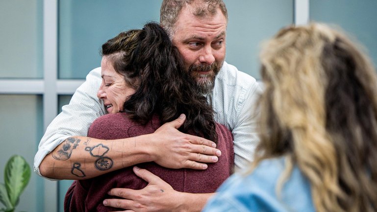 Utah County Sheriff's Deputy Jake Hall, lead detective on the case, looks to other family members as he hugs Tommi Aime, youngest sister of Laura Ann Aime.