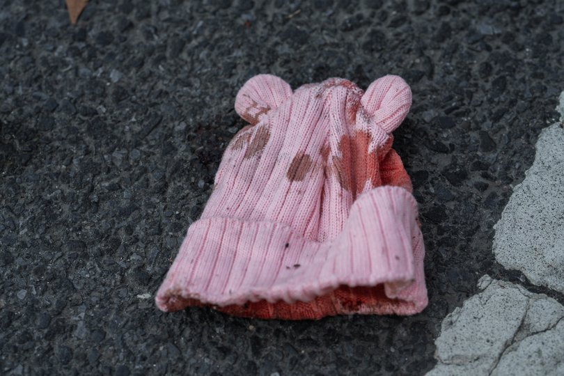A child's blood-soaked hat lies on the ground at the scene of the fatal shooting of a seven-month-old infant in the Brooklyn.