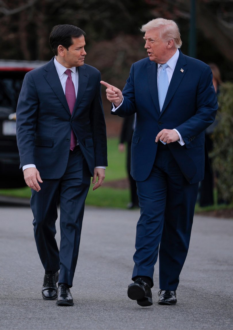 President Donald Trump talks with U.S. Secretary of State Marco Rubio (L) as he departs the White House.