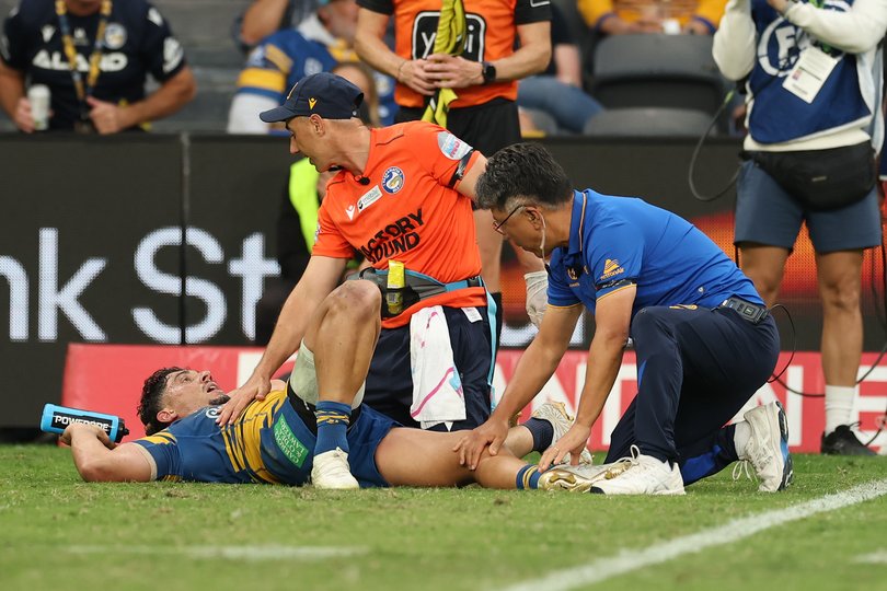 Bailey Simonsson of the Eels is helped by trainers.