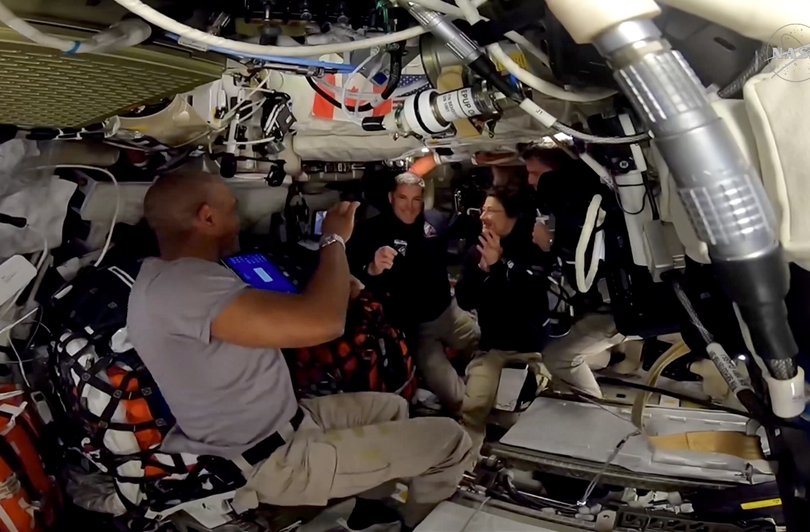 In a video still from NASA, the crew of Artemis II celebrates Easter Sunday by presenting Jeremy Hansen of the Canadian Space Agency with golden astronaut wings.