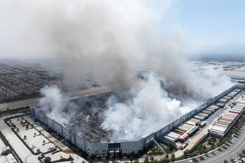 Thick smoke billows from the roof of the Kimberly-Clark paper products facility on April 7, 2026 in Ontario, California..