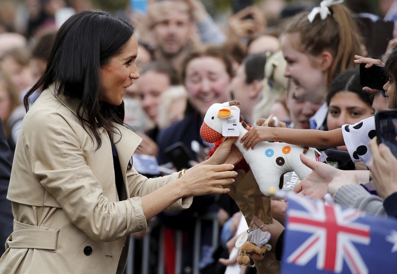 Meghan receives a gift from the crowd during a walkabout.