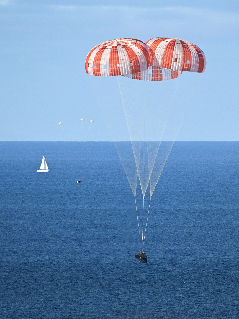 PHOTO DATE: April 10, 2026.LOCATION: Off the coast of California. SUBJECT: NASA’s Orion capsule descends under its main parachutes over the Pacific Ocean following a successful 1-day Artemis II mission, April 10, 2026. 