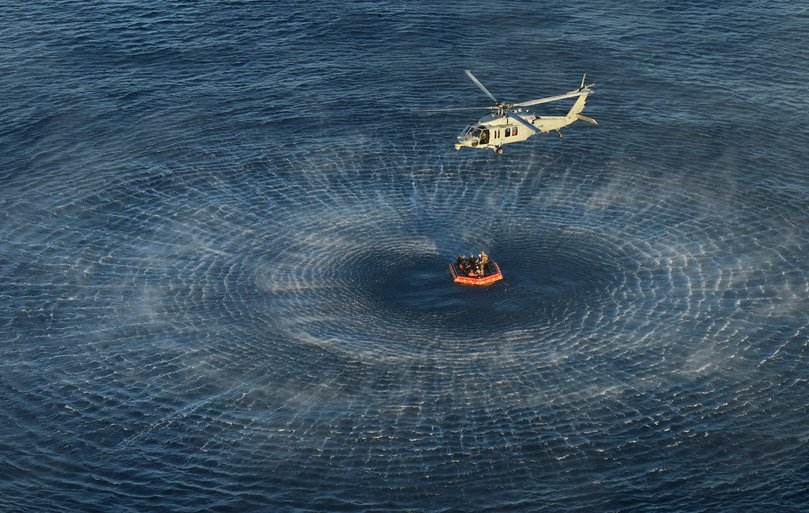 NASA Artemis II crew members are hoisted into a U.S. Navy MH-60 helicopter after successfully splashing down in the Pacific Ocean.