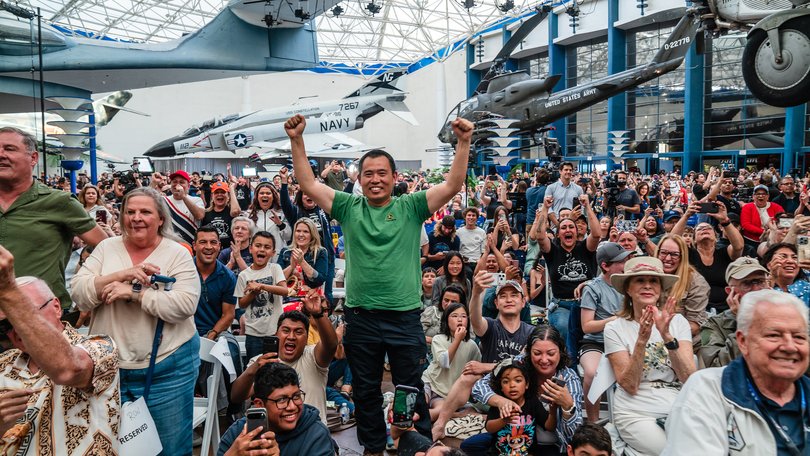 A crowd cheers at the San Diego Air and Space Museum.