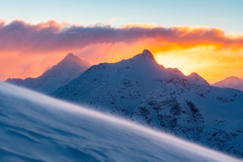 Fiery sky at sunrise over snowcapped mountains, Val di Rezzalo, Stelvio National Park, Valtellina, Lombardy, Italy.