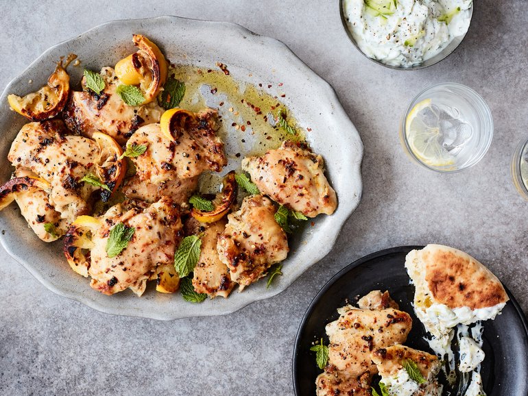 Roasted chicken thighs with garlicky cucumber yoghurt in New York on Sept. 10, 2021. Delicate boneless, skinless thighs cook quickly, aren't prone to drying out and pair beautifully with a garlicky cucumber yoghurt. Food Stylist: Simon Andrews. Prop Stylist: Christina Lane.(Johnny Miller/The New York Times)