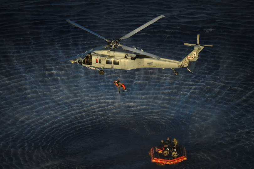 A photo provided by NASA shows Artemis II crew members hoisted into a US Navy MH-60 helicopter.