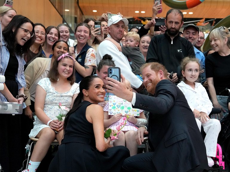 Meghan and Prince Harry pose for a selfie with children and their families during a visit to the Royal Children's Hospital on April 14, 2026 in Melbourne.