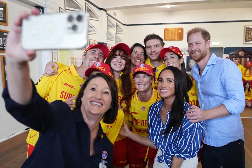 The Duke and Duchess of Sussex pose for a selfie as they meet volunteer first responders from Bondi Surf Bathers' Life Saving Club.