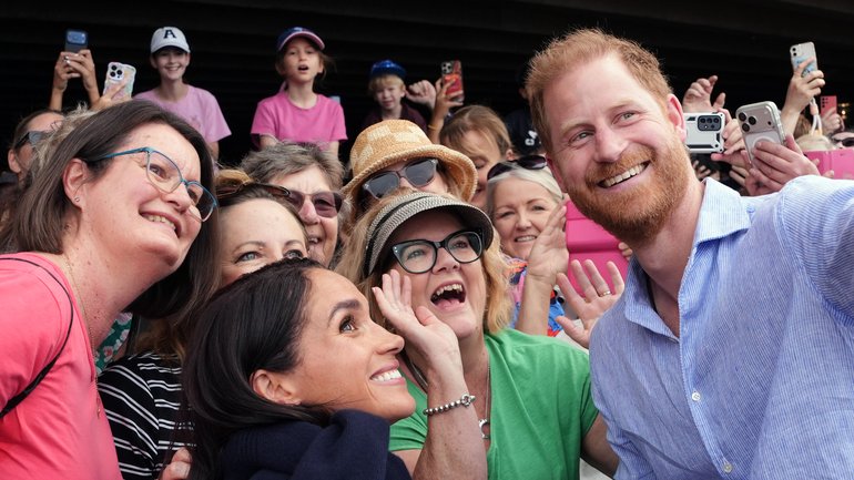 Prince Harry and Meghan take a selfie with well-wishers at a sailing event with members of Invictus Australia in Sydney Harbour, on day four of the royal trip on April 14, 2026.