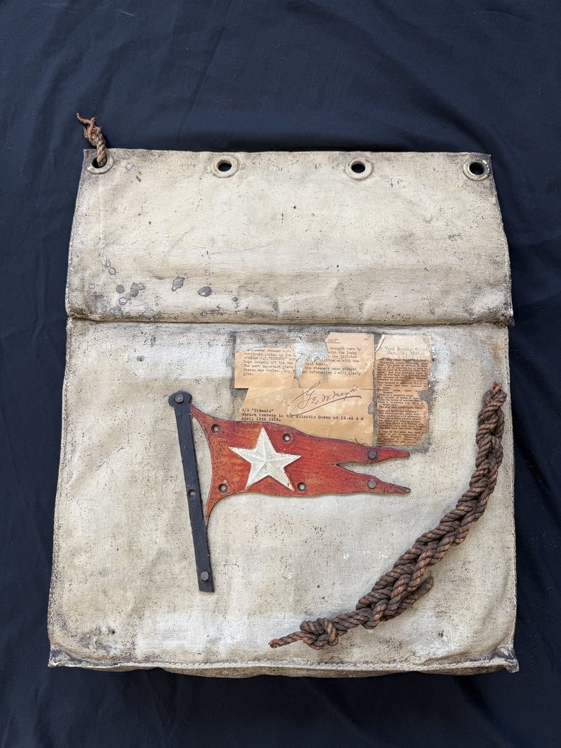 A seat cushion from one of the lifeboats of the Titanic, which features an original Titanic lifeboat plaque in the form of a White Star burgee, sold for £390,000.