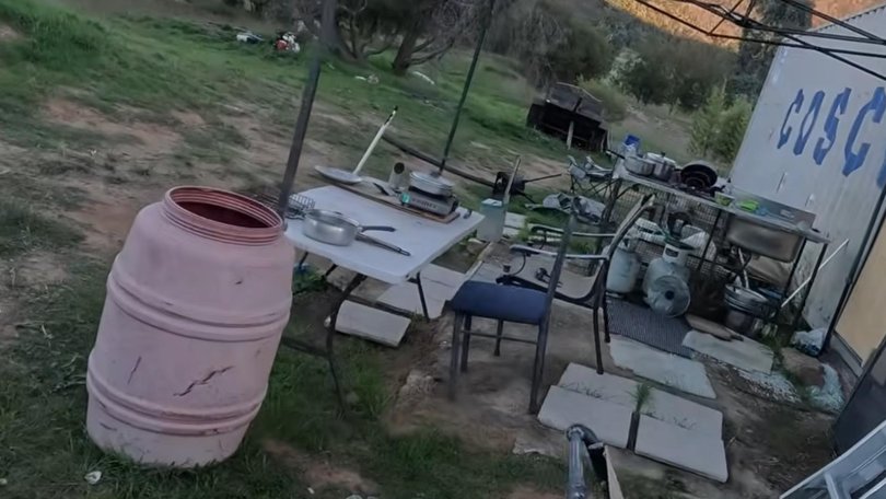 Rubbish and equipment litter the property. 