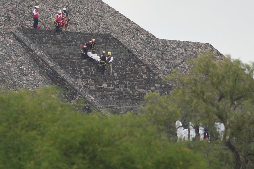 Forensic workers carry the body of a victim down a pyramid after authorities said a gunman opened fire, in Teotihuacan, Mexico, Monday, April 20, 2026. (AP Photo/Eduardo Verdugo)
