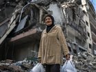A woman displaced by the fighting near her home in Marjayoun, Lebanon, carries belongings in plastic bags in Dahiyeh, a suburb south of Beirut.