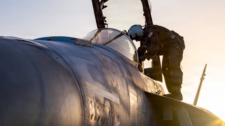 An air force pilot climbs aboard a jet in the Middle East. 