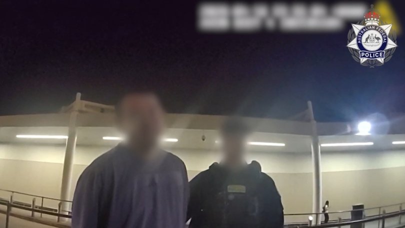 In blurred footage, officers can be seen speaking to the man after he was restrained mid-flight. Picture: AFP