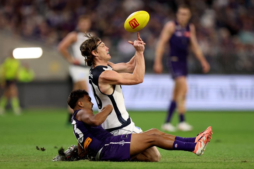 Sam Walsh of the Blues handpasses the ball under pressure. 