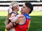Lachie Neale carries daughter Piper out to the MCG for his milestone game.
