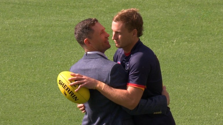 Jordan Dawson and Joel Selwood share an embrace before the Adelaide-Brisbane clash.