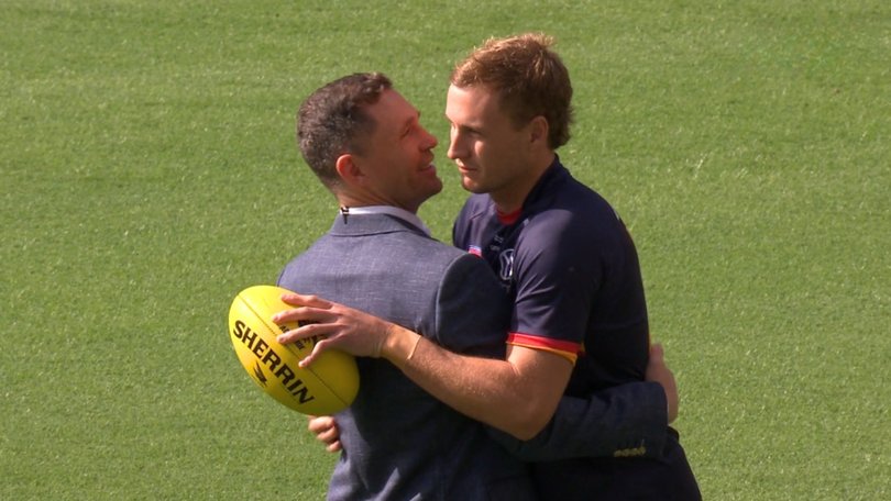 Jordan Dawson and Joel Selwood share an embrace before the Adelaide-Brisbane clash.