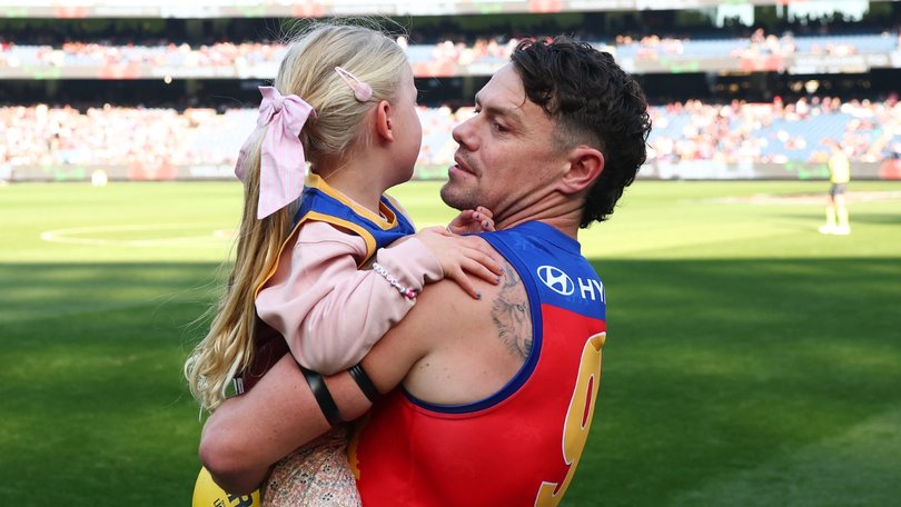 Lachie Neale carries daughter Piper out to the MCG for his milestone game.