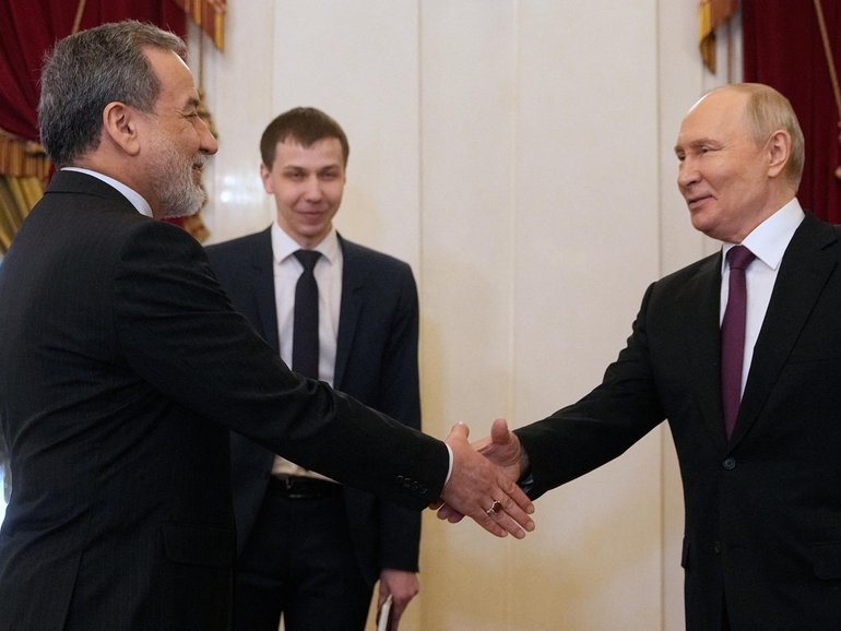 Russian President Vladimir Putin shakes hands with Iranian Foreign Minister Abbas Araghchi during their meeting in Saint Petersburg.