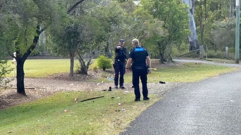 Officers comb the roadside for evidence.