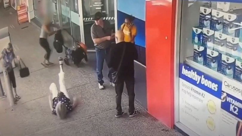 The elderly woman falls to the ground after being struck by a pram in the middle of the footpath.