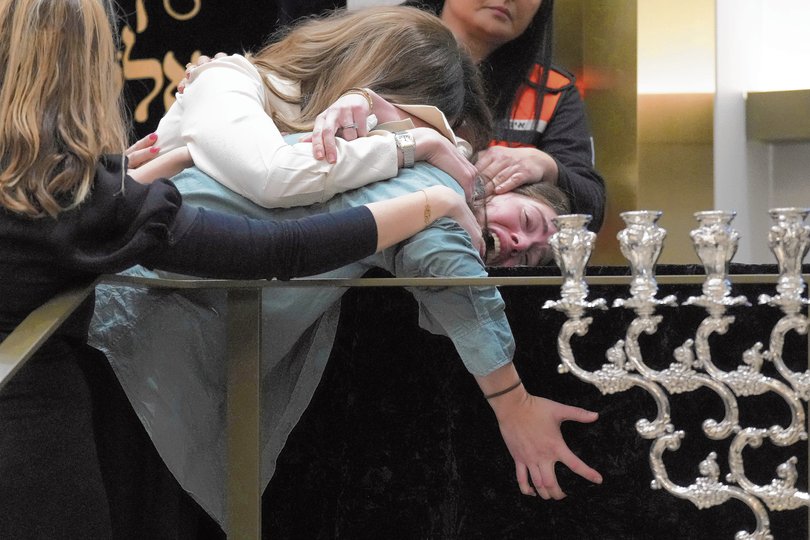 SYDNEY, AUSTRALIA - DECEMBER 17: Family grieve at the coffin of Rabbi Eli Schlanger, a victim in the Bondi Beach mass shooting, during his funeral at Chabad of Bondi on December 17, 2025 in Sydney, Australia. Police say at least 16 people, including one suspected gunman, were killed and more than 40 others injured when two attackers opened fire near a Hanukkah celebration at Bondi Beach, in what authorities have declared a terrorist incident. (Photo by Mark Baker-Pool/Getty Images)