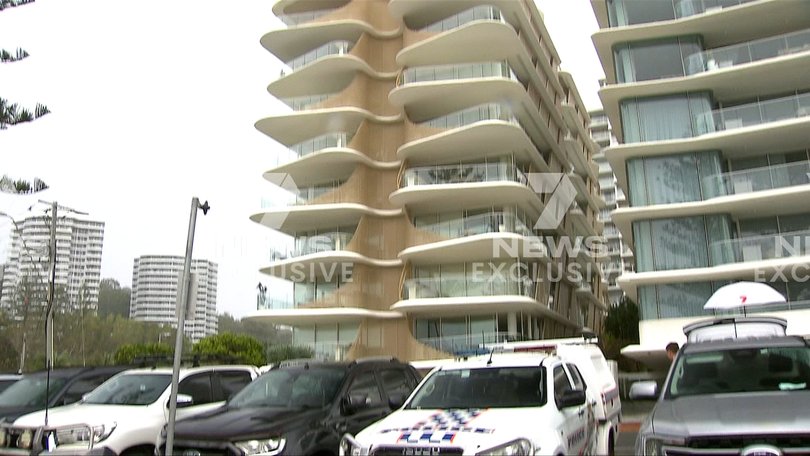 Police officers are seen on the balcony of the Burleigh Heads apartment during the search operation.