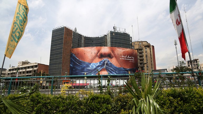 A giant banner depicting the Strait of Hormuz is displayed n Tehran, with the lips of Donald Trump.