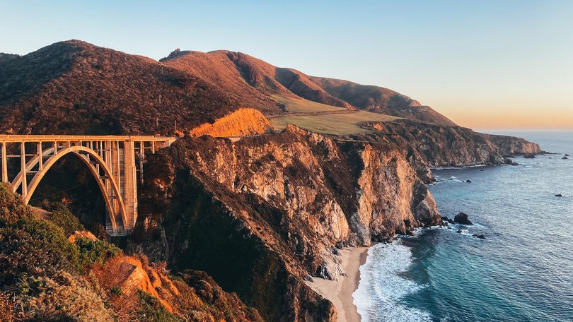 The Bixby Creek Bridge, Pacific Coast Highway 1 and greater Californian Big Sur coastline with a dramatic sunset. 