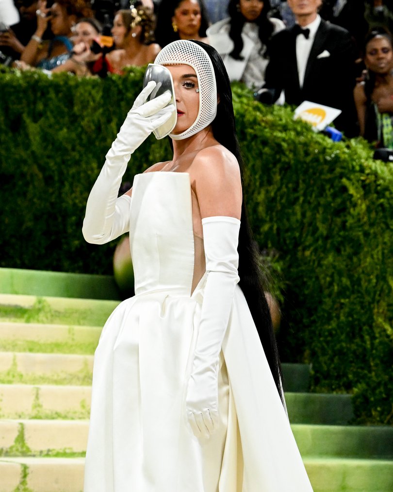 Katy Perry removes her beekeeper mask on the red carpet. 