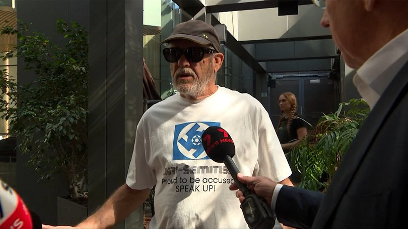 Ian Minus outside the Bondi Royal Commission in Sydney wearing a swastika shirt.