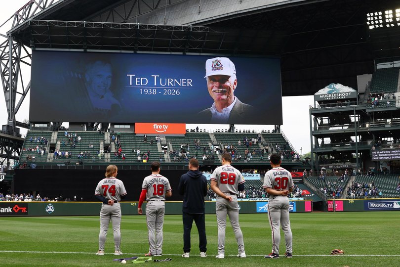 Members of the Atlanta Braves stand during a tribute to Braves owner Ted Turner prior to the game between the Atlanta Braves and the Seattle Mariners at T-Mobile Park.