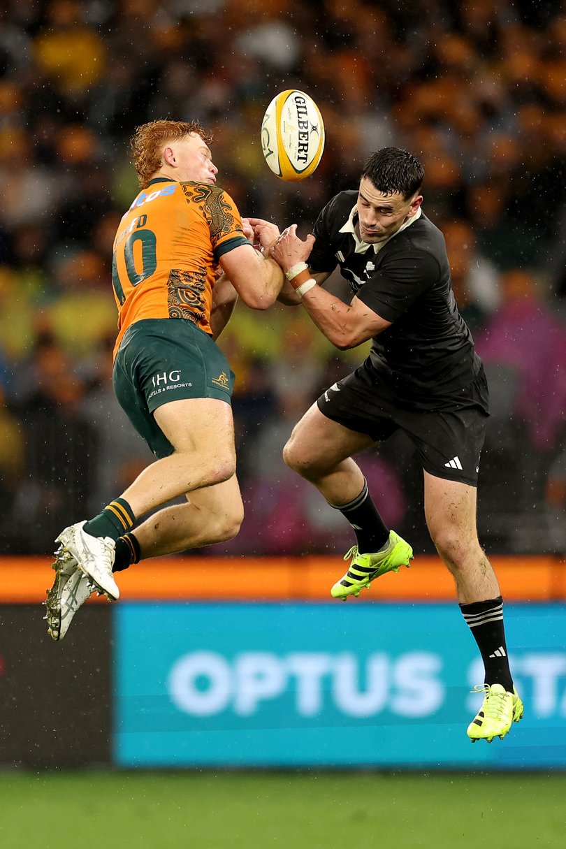 Tane Edmed of the Wallabies and Will Jordan of the All Blacks compete for a high ball.