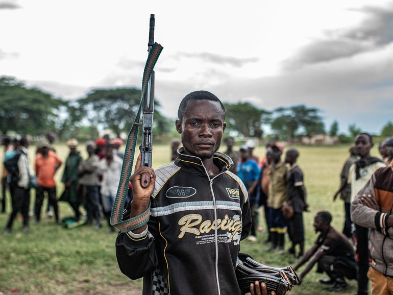 A Wazalendo militant surrenders a weapon to members of the Rwanda-backed M23 rebel group on December 15, 2025.