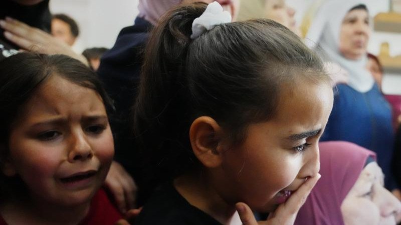 Children cry at the funeral for the Palestinian man shot trying to climb the wall to find work.