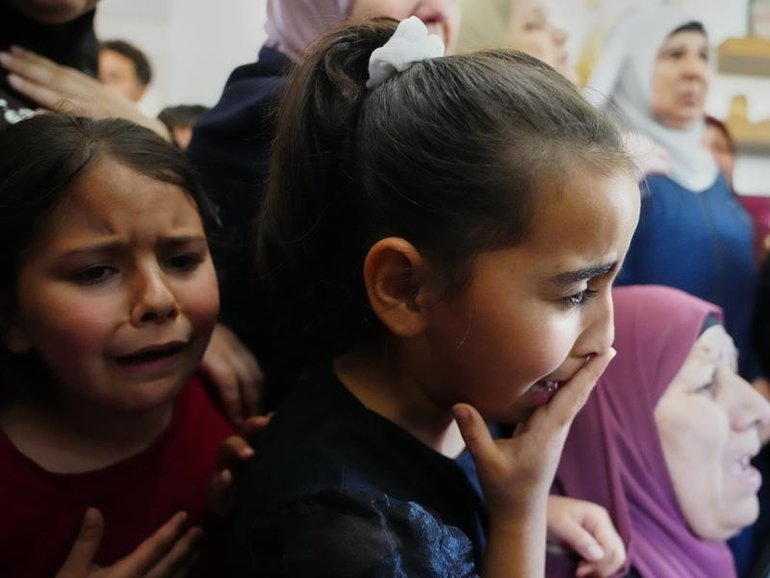 Children cry at the funeral for the Palestinian man shot  trying to climb the wall to find work.