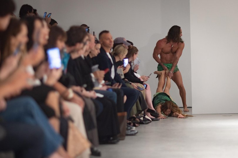 US artist Kirsha Kaechele was pulled by her legs onto the catwalk by her male model partner, as the crowd attempted to conceal their laughter at the outlandish scene.