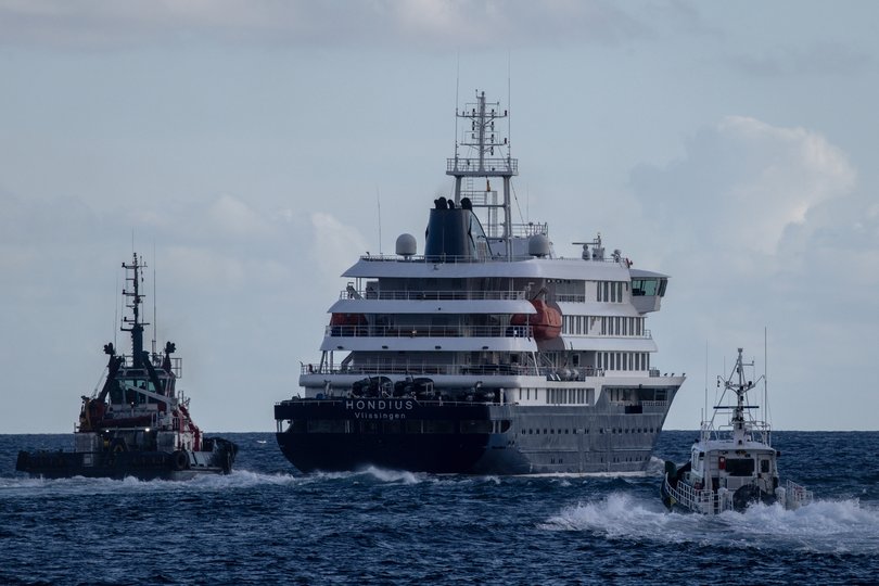 Port vessels accompany the MV Hondius as it departs the Granadilla Port after all passengers were evacuated.