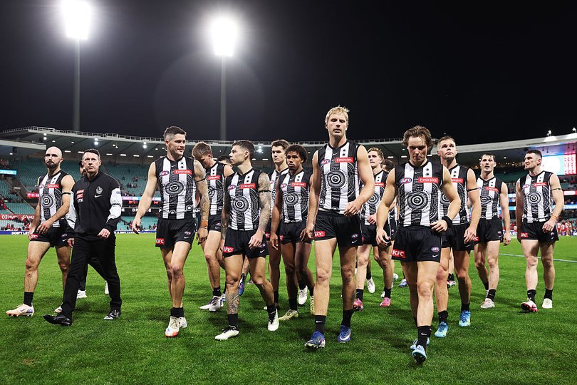 Dejected Collingwood players leave the SCG after losing a thriller against the Swans.