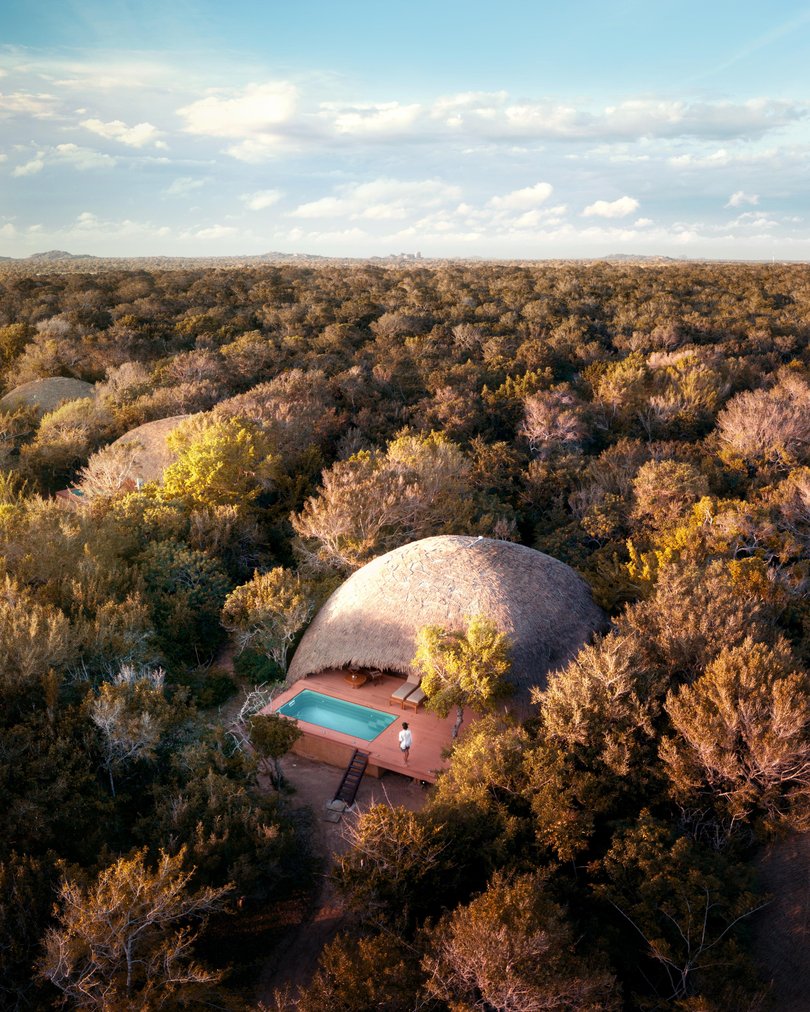 Bungalows stretch along a barren shoreline where the jungle thins into the beach.