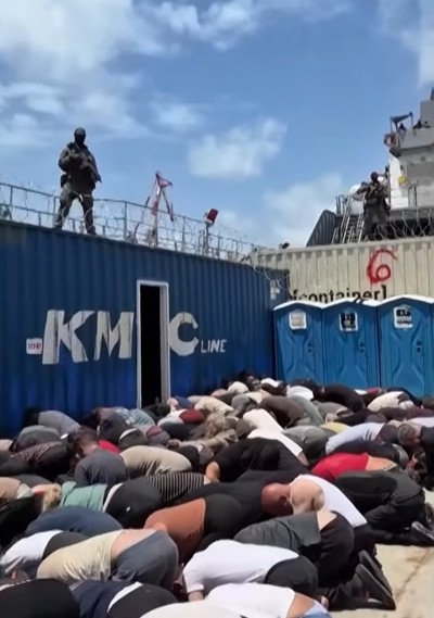 The footage also shows armed guards watching bound activists.