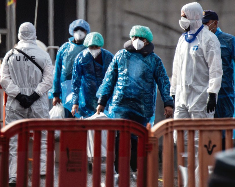 Passengers carry their belongings in plastic bags after being evacuated from the MV Hondius after docking in the Granadilla Port  on May 10, 2026 in Tenerife, part of the Canary Islands, Spain. 