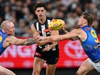 Scott Pendlebury handballs as the Eagles apply pressure.